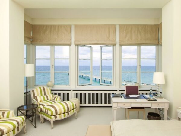 hotel living area with desk and sofa overlooking the sea