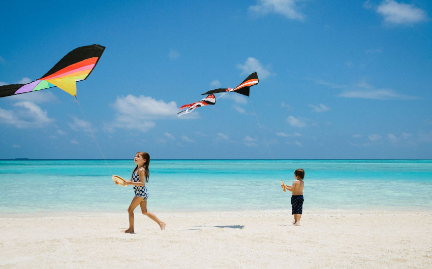 Niyama Private Islands Flying Kites on Beach with The Little Voyager