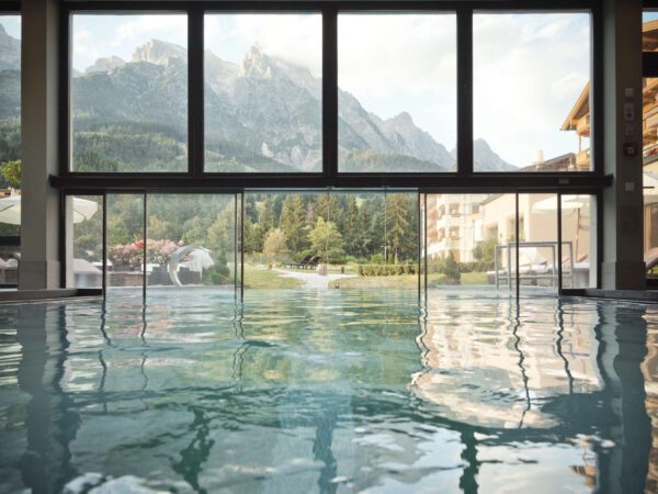 Indoor pool looking at outdoor pool at Hotel Forsthofgut