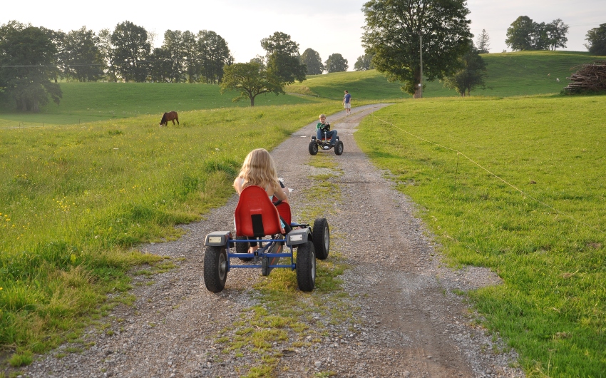 Children riding pedal tractors on grounds of the Bavarian Farm