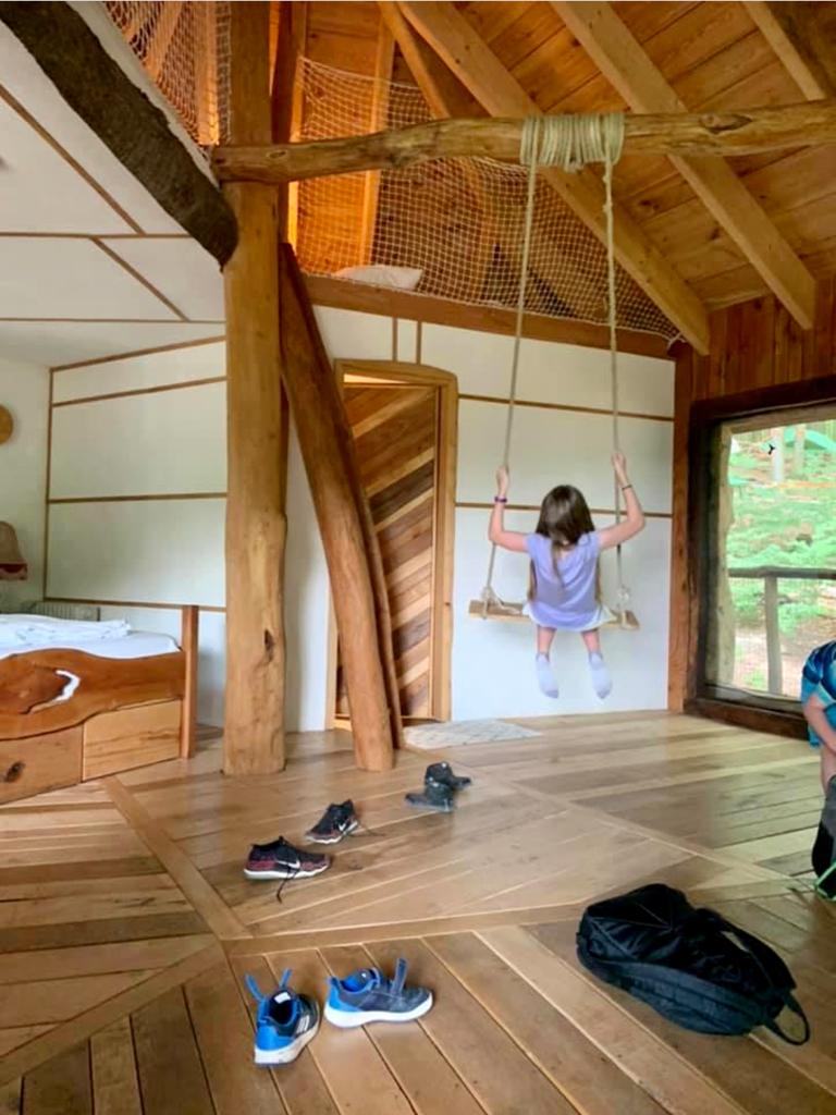 Girl on swing inside treehouse at the German Treehouses