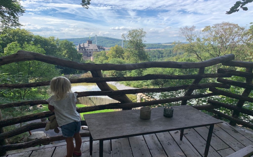 girl looking at the view from the balcony at the German Treehouses