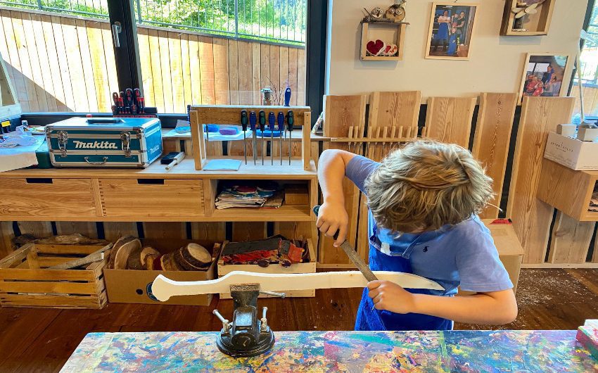 Boy working with wood at the South Tyrolean Panorama Retreat