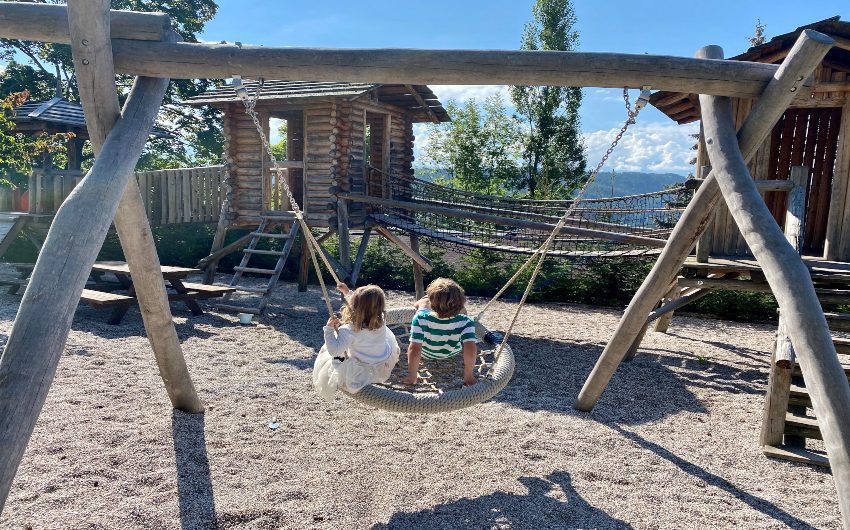 Kids on swing at the South Tyrolean Art Nouveau Hotel