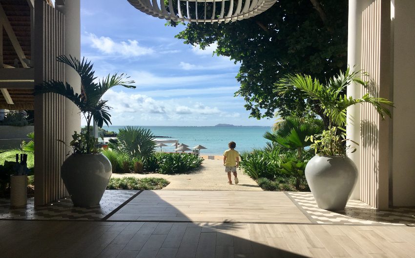 Boy walking towards beach at LUX* Grand Gaube