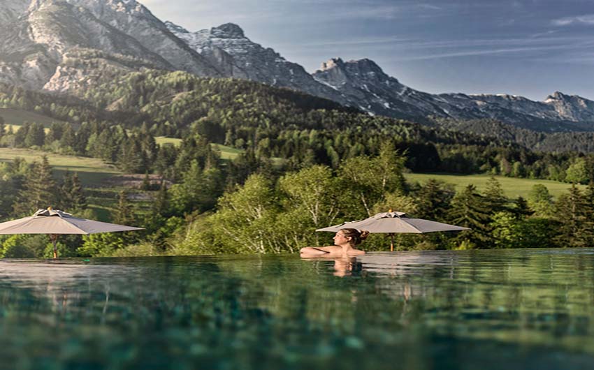 Outdoor pool with mountain views in summer at the Austrian Nature Escape