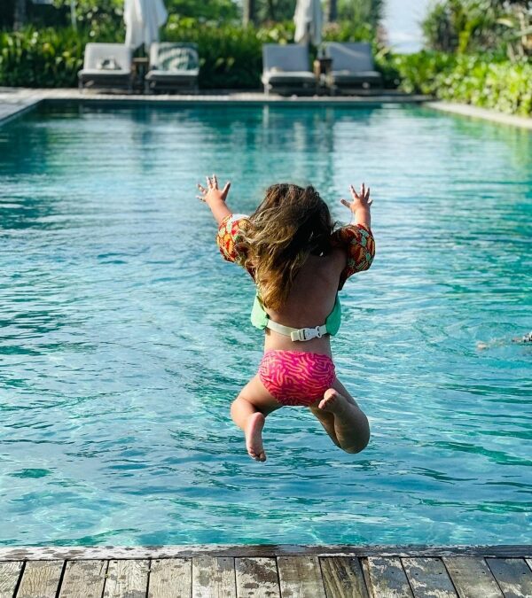 Girl jumping into a pool at Como Uma Canggu in Bali