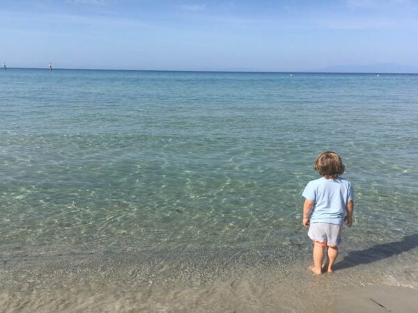 child on beach in front of sea