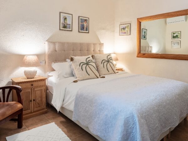 a double bedroom with a chair and mirrors