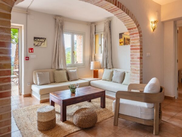 a cosy living area with sofa and door leading to terrace