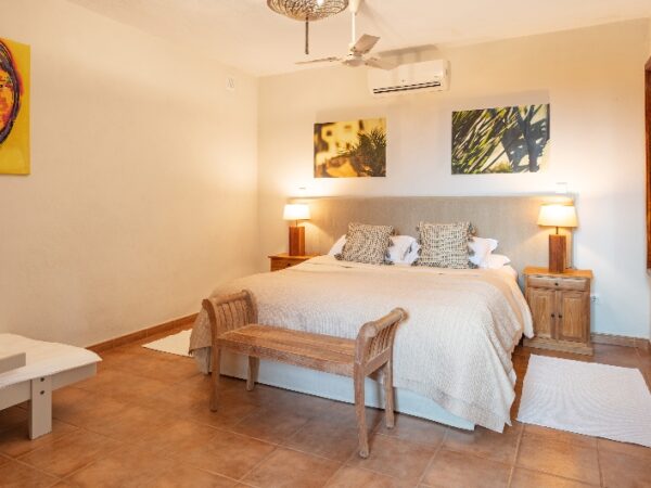 a large bedroom with a double bed and soe pictures on the wall