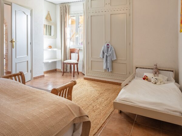 A large bedroom with a double bed and a child bed