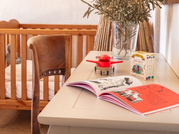 childrens cot next to table with children's books